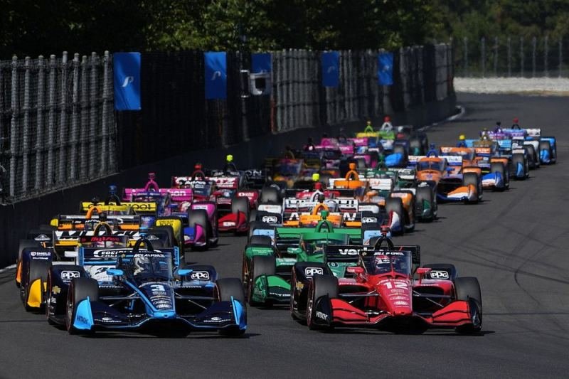 Salida de una carrera de IndyCar con varios monoplazas en pista