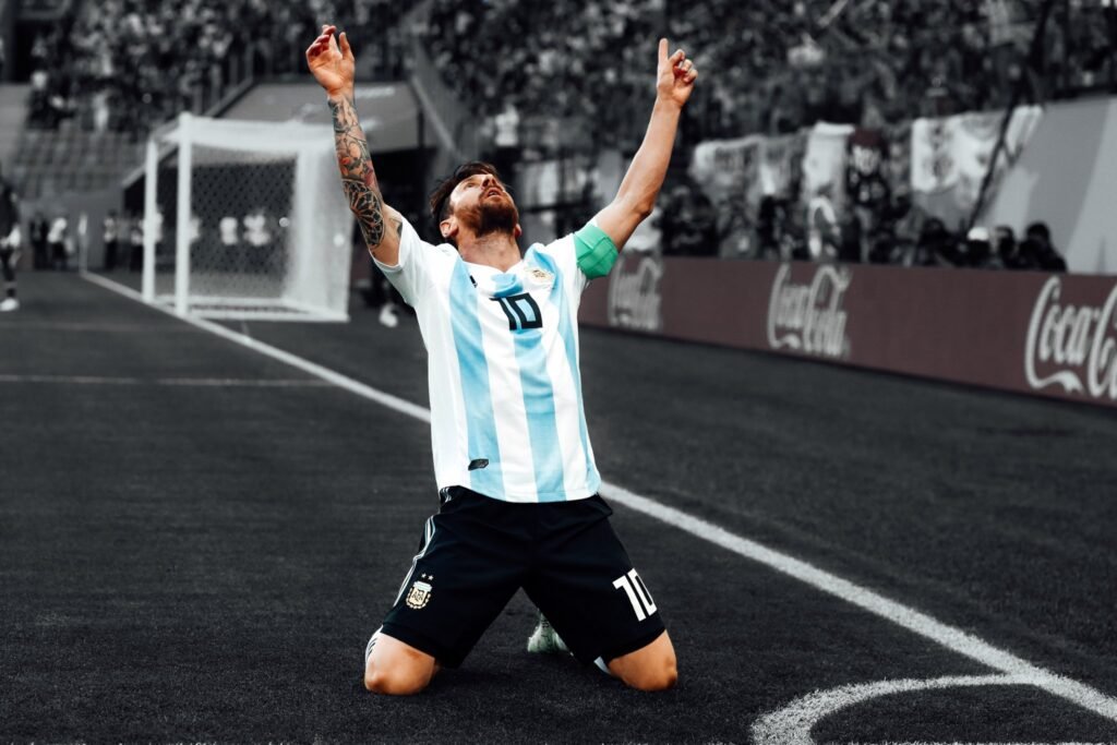 Lionel Messi celebra de rodillas con los brazos en alto vistiendo la camiseta de Argentina