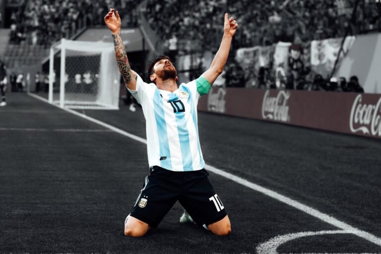 Lionel Messi celebra de rodillas con los brazos en alto vistiendo la camiseta de Argentina