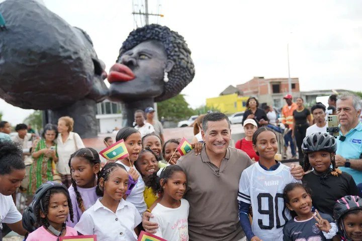 Niñas y niños de Tierra Baja frente a la escultura Luna de Bembeo, en la glorieta de la nueva vía de acceso