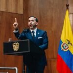 El presidente Abelardo De La Espriella levanta el dedo índice mientras habla desde un atril de madera, junto a la bandera de Colombia