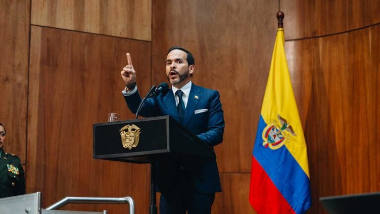 El presidente Abelardo De La Espriella levanta el dedo índice mientras habla desde un atril de madera, junto a la bandera de Colombia