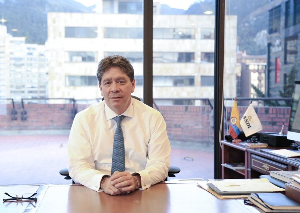 Bruce Mac Master en su oficina de la ANDI, con las banderas de Colombia y del gremio al fondo