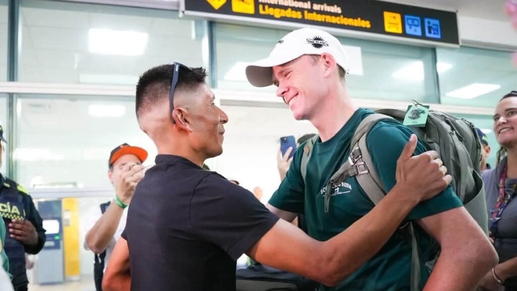 Chris Froome, con gorra blanca y morral, recibe un abrazo a su llegada a la sala de llegadas internacionales del aeropuerto