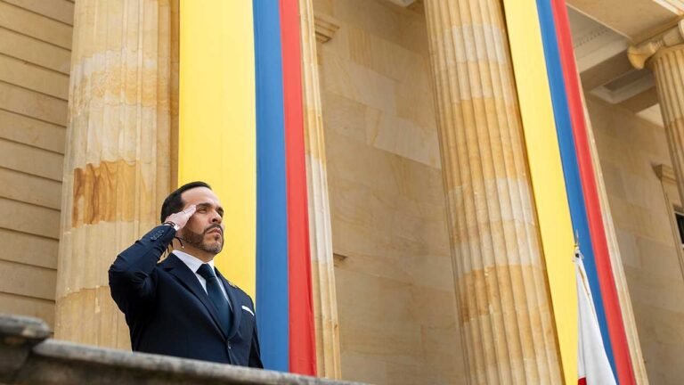 El presidente Abelardo De La Espriella hace el saludo militar en un balcón entre columnas y banderas de Colombia