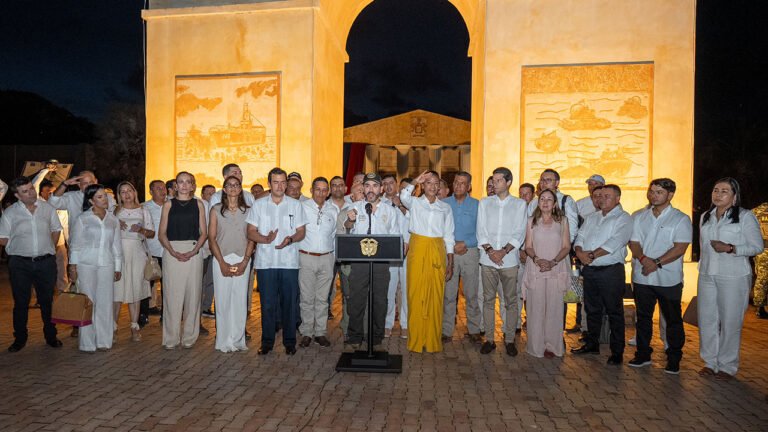 El presidente Abelardo De La Espriella habla en atril junto a la gobernadora y los alcaldes de Sucre, de noche, frente a un monumento iluminado en Coveñas
