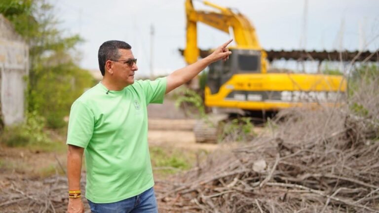 El alcalde Dumek Turbay señala hacia una retroexcavadora durante un recorrido por un terreno en obra