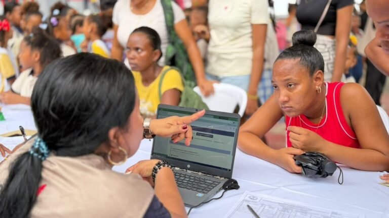 Una funcionaria atiende con un computador portátil a una habitante de Bocachica durante la jornada Gobierno al Barrio