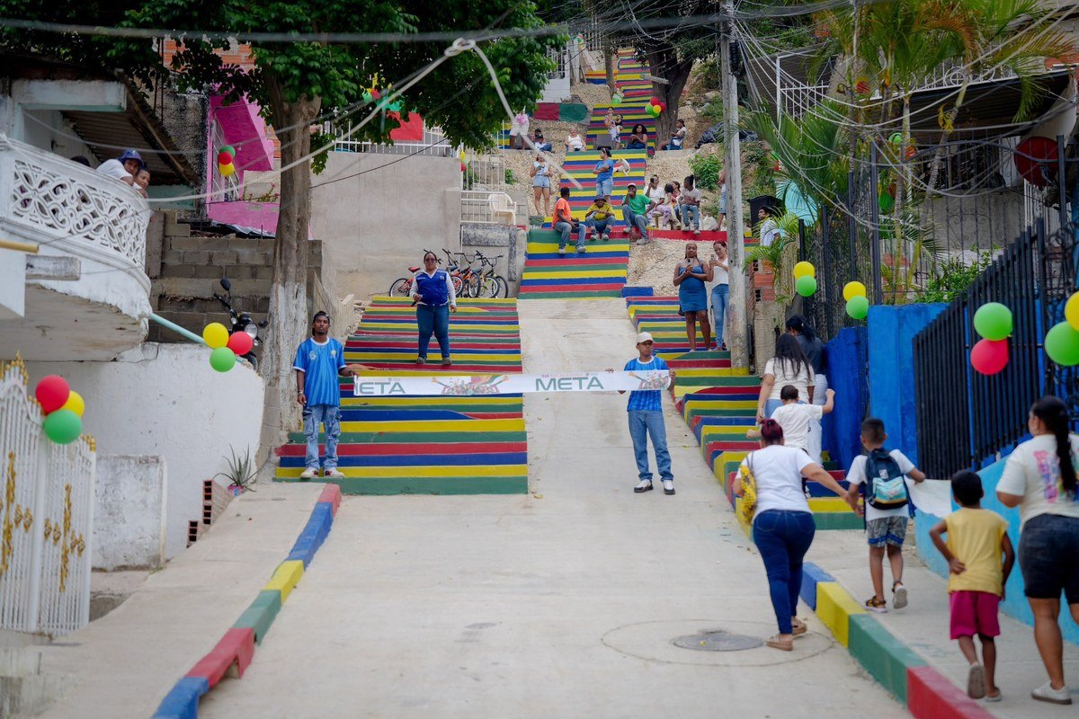 Calle 51 de La María pavimentada, con escaleras pintadas de colores y vecinos subiendo la pendiente