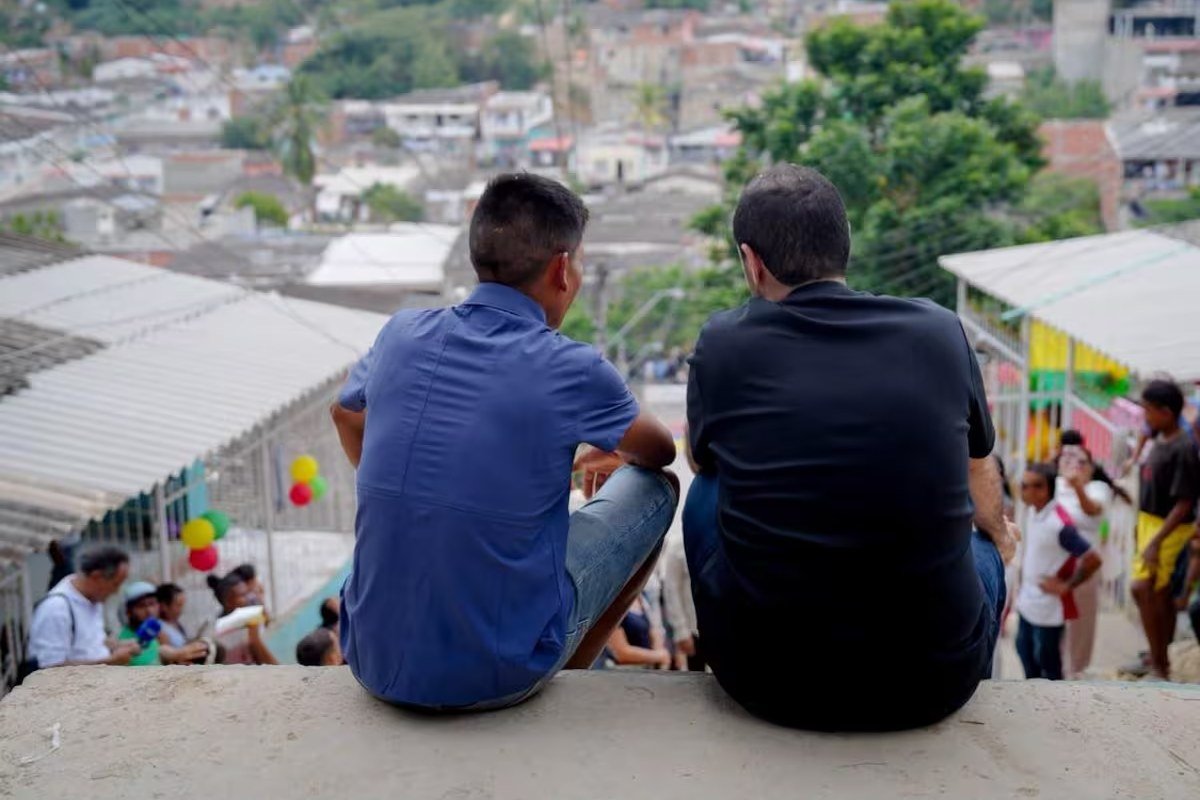 Nairo Quintana y el gobernador Yamil Arana, sentados de espaldas, observan el barrio La María desde lo alto de la calle