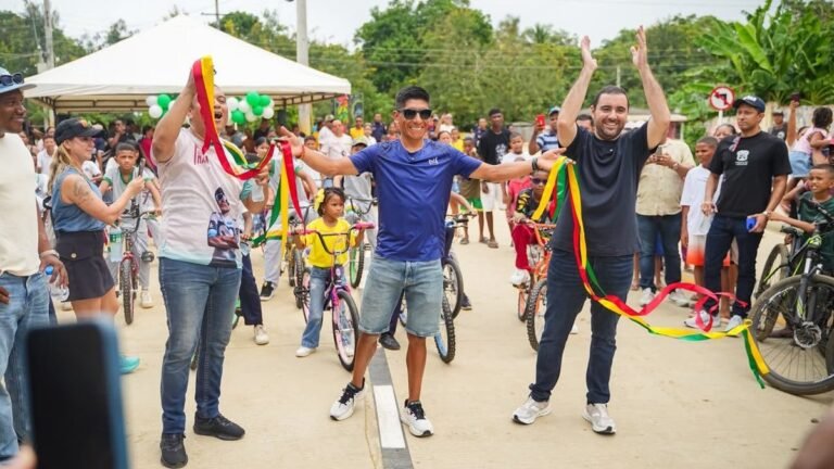 Nairo Quintana y el gobernador Yamil Arana, con cintas tricolor, celebran con niños en bicicleta y habitantes durante su recorrido por Bolívar