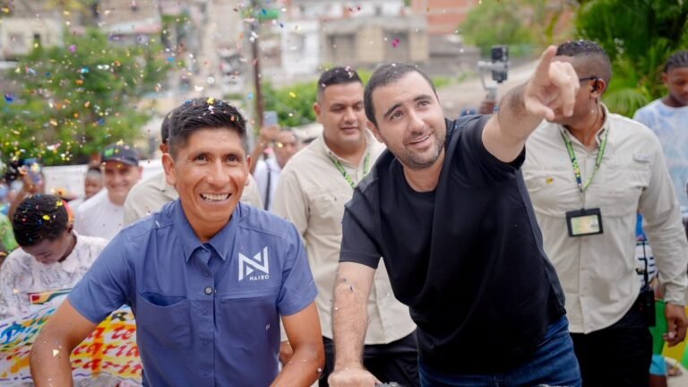 Nairo Quintana y el gobernador Yamil Arana, con una bicicleta, celebran con habitantes de La María la entrega de la vía pavimentada