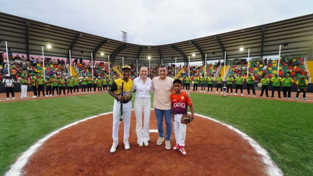 Acto de apertura en el estadio de béisbol menor de Nuevo Chambacú, con jugadores en el campo y las graderías llenas