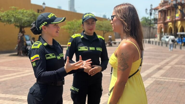 Dos policías de turismo conversan con una visitante en una plaza del Centro Histórico de Cartagena