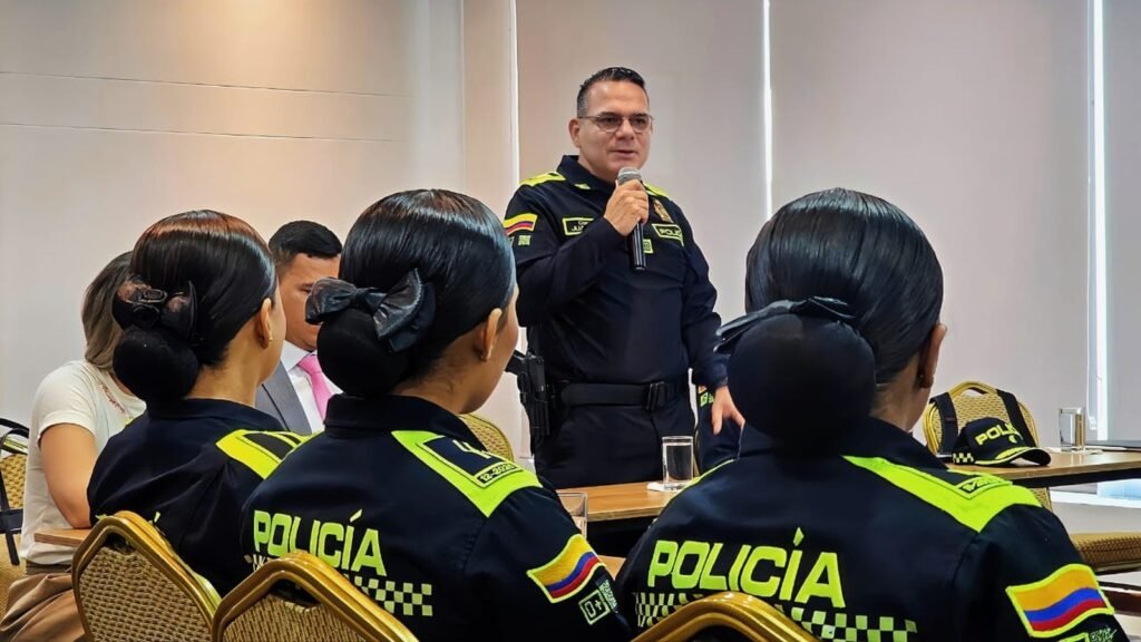 El coronel Juan Pablo Ruiz habla con micrófono ante policías de Cartagena durante el entrenamiento contra la trata de personas