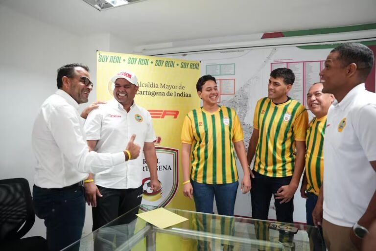 Directivos y socios del Real Cartagena posan con la camiseta auriverde frente al escudo del club